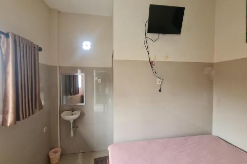 a small room with a bed and a sink at Capital O 93250 Hotel Tirta Kencana 2 Baturaden in Banyumas