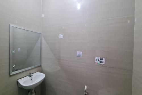 a white bathroom with a sink and a mirror at Capital O 93250 Hotel Tirta Kencana 2 Baturaden in Banyumas