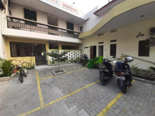 two motorcycles parked in a parking lot in front of a building at OYO 93274 Oren Home Bekasi in Bekasi