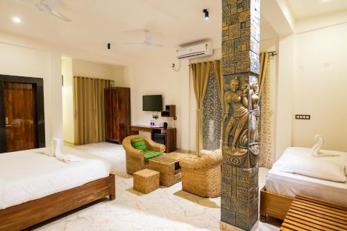 a bedroom with two beds and a statue of a woman at The Kaziranga Address in Kāziranga