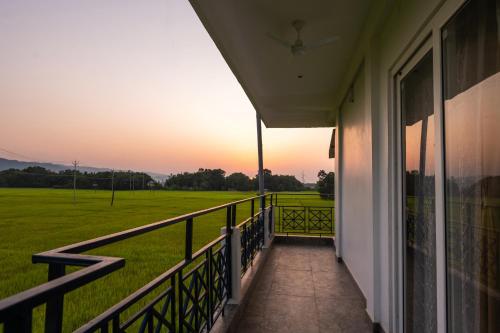 a balcony of a house with a view of a field at The Kaziranga Address in Kāziranga