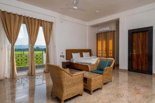 a bedroom with a bed and a table and chairs at The Kaziranga Address in Kāziranga