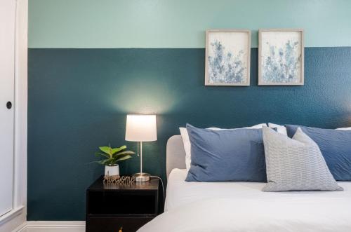 a bedroom with a blue accent wall and a bed at Elegant Retreat w/ Game room in Heart of OC in Midway City