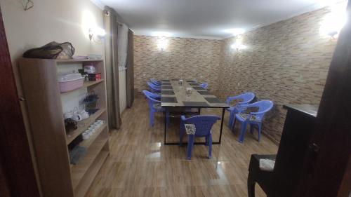 een eetkamer met een tafel en blauwe stoelen bij INJIR Hostel in Doesjanbe