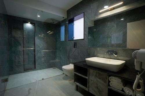 y baño con lavabo, ducha y aseo. en Bageecha Resort en Pushkar