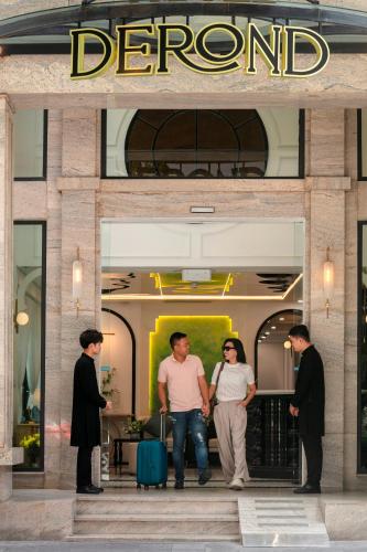 a group of people standing outside of a store doorway at Hotel De Rond in Hanoi