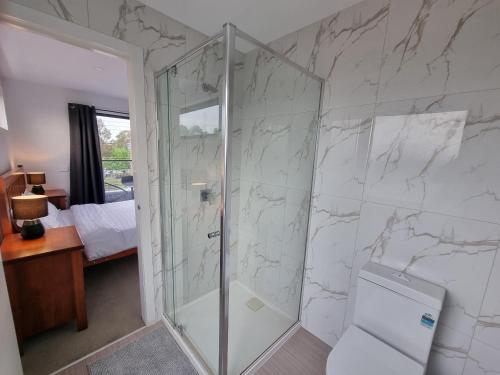 a bathroom with a glass shower with a toilet at Rosie Townhouse in prime location close to CBD in Melbourne