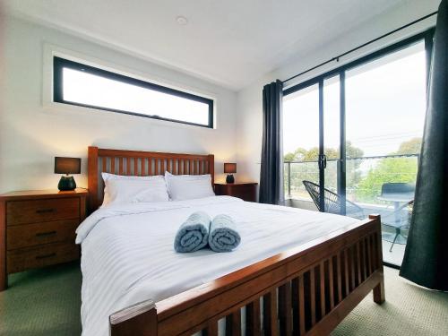 a bedroom with a bed with two blue towels on it at Rosie Townhouse in prime location close to CBD in Melbourne