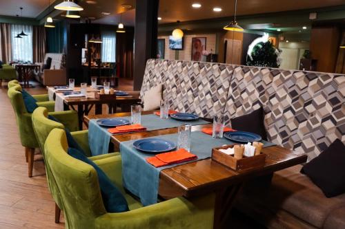Отель KOKSHETAU في كوكشيتو: غرفة طعام مع طاولات وكراسي خضراء