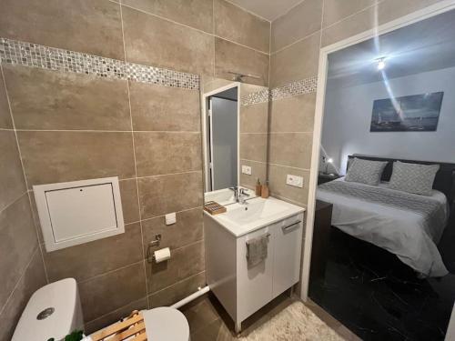 a bathroom with a sink and a toilet and a bed at A louer Appartement 2 pièces à Rosny-sous- Bois in Rosny-sous-Bois