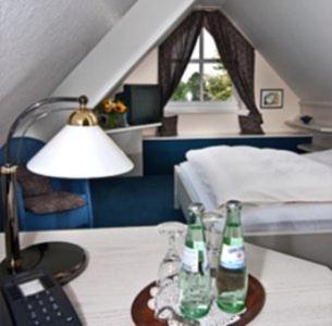 a room with a bed and two bottles on a table at Marienthaler Gasthof in Marienthal