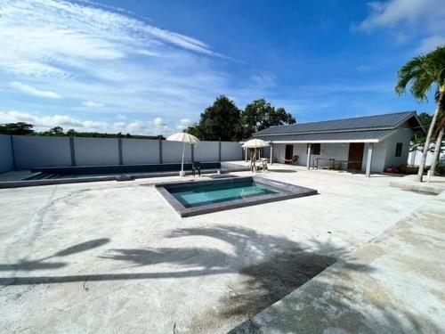 a backyard with a swimming pool and a house at Dream Villa Homestay Kuala Nerang in Kuala Nerang