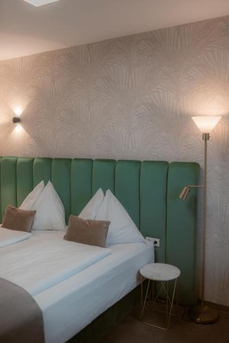 a bedroom with a bed with a green and white wall at NED Hotel in Graz