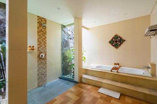 un baño con bañera y ducha en Lasanti Villas Seminyak, en Seminyak