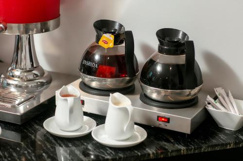 a counter with two coffee makers and plates on it at Hotel De Rond in Hanoi