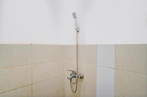 y baño alicatado con ducha y manguera. en OYO 93224 Fj Guest House, en Sayang