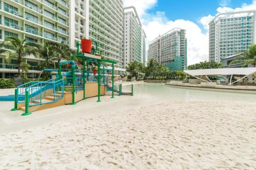 a playground on the beach in front of buildings at Azure Urban Resort and Residences Bahamas Tower in Manila