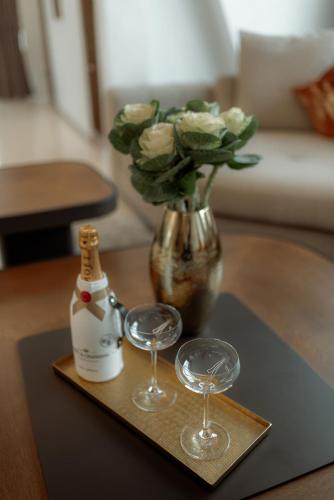 a tray with two wine glasses and a vase with flowers at NED Hotel in Graz