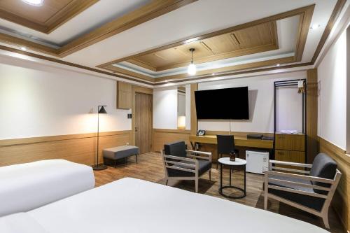 スウォンにあるCentral Plaza Hotelのベッド1台、薄型テレビが備わるホテルルームです。
