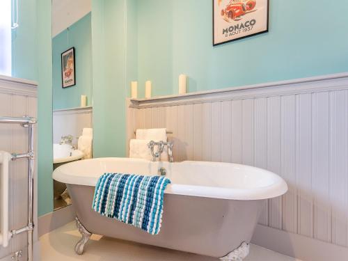 a bathroom with a bath tub and a sink at Staggart House in Banff