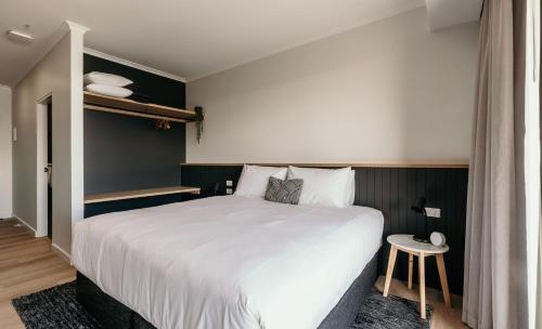 a bedroom with a large white bed and a table at Met Apartments in Port Lincoln
