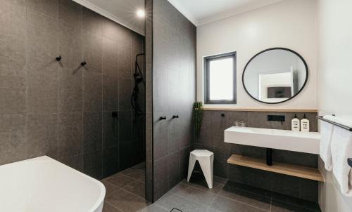 a bathroom with a toilet and a sink and a mirror at Met Apartments in Port Lincoln