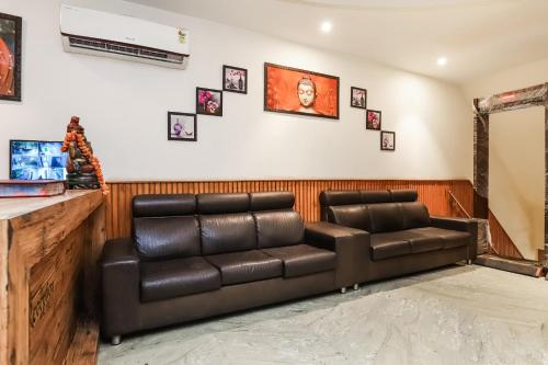 a waiting room with a leather couch and a mirror at OYO Flagship Hotel Shri Sai in New Delhi