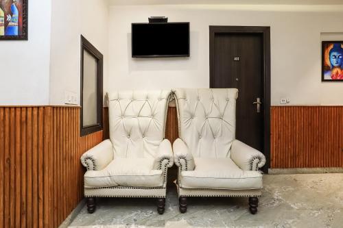 two white chairs in a room with a tv at OYO Flagship Hotel Shri Sai in New Delhi