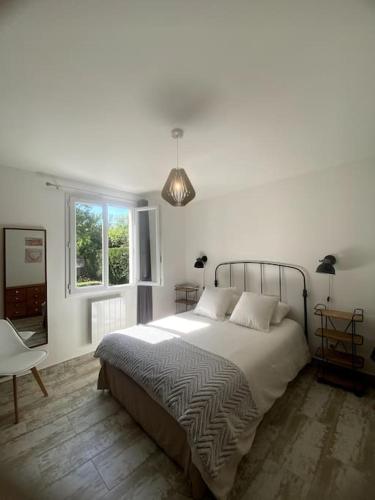 une chambre avec un grand lit et une fenêtre dans l'établissement Charmante Maison au pied du Luberon, à Cheval-Blanc