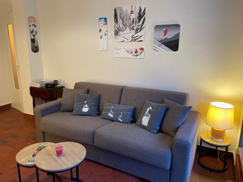 un salon avec un canapé et deux tables dans l'établissement Résidence Bois du Bouchet, appartement vue montagne, calme, parking gratuit, proche centre, à Chamonix-Mont-Blanc