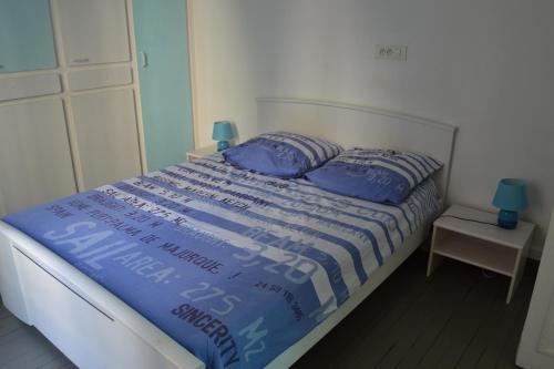 een bed met blauwe kussens in een slaapkamer bij Marguerite in Saint-Malo