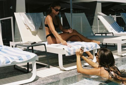 twee vrouwen in badpakken in een zwembad bij 71 Hastings Street - Beachfront in Noosa Heads