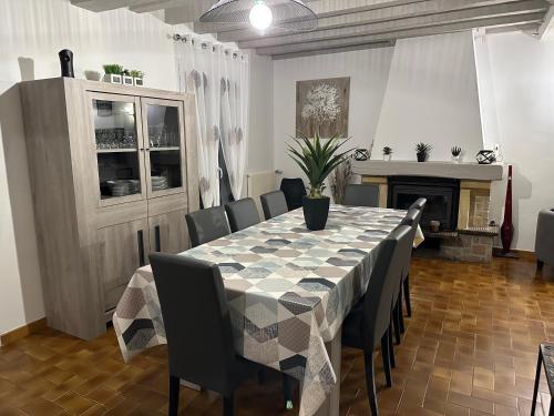 a dining room with a table and chairs and a fireplace at Escapade entre Terre et Mer in Guilmécourt