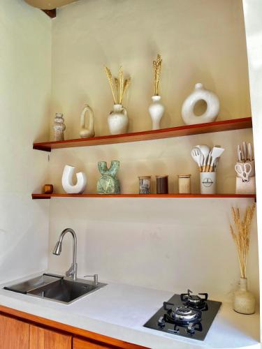 a kitchen counter with a sink and some shelves at Sampai Villa Bohemian in Kentisari