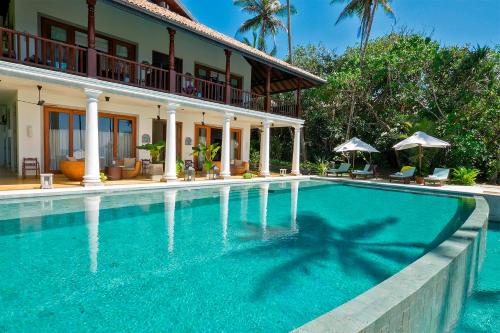 a swimming pool in front of a villa at Eraeliya Villas & Gardens in Weligama