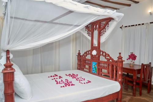 a bedroom with a bed with pink roses on it at Beach Way Villa in Malindi