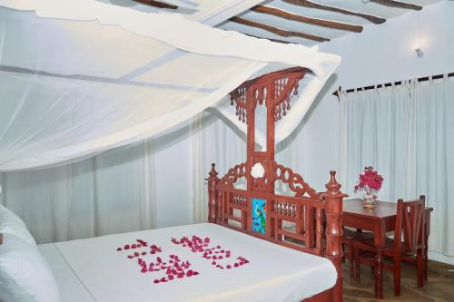 a bedroom with a bed with red roses on it at Beach Way Villa in Malindi