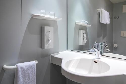 a white bathroom with a sink and a mirror at Michel Hotel Hodenhagen in Hodenhagen