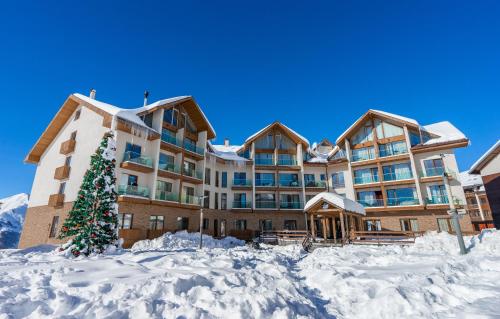 a large building with a christmas tree in the snow at New Gudauri Ski4Life in Gudauri