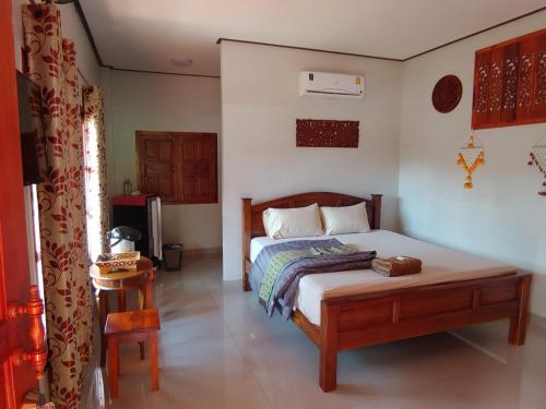 a bedroom with a bed and a television in it at Jasmin Resort in Mae Hong Son