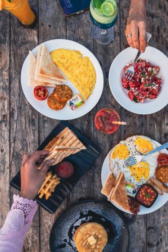 een tafel met borden ontbijt erop bij Raposo Resorts in Vagator