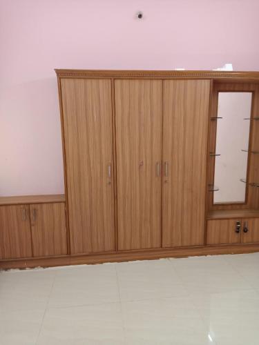 een grote houten kast met een raam in een kamer bij 1 BHK House with AC fully operational kitchen with wifi in Hyderabad