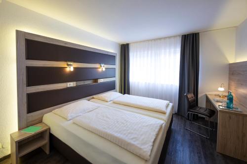 a hotel room with a bed and a desk at Michel Hotel Hodenhagen in Hodenhagen