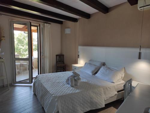 - une chambre avec un lit et une porte coulissante en verre dans l'établissement B & B Korello, à Gasponi