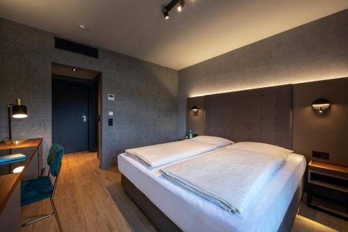 a bedroom with a large bed and a desk at Michel Hotel Hodenhagen in Hodenhagen