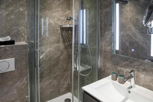 a bathroom with a glass shower and a sink at Michel Hotel Hodenhagen in Hodenhagen