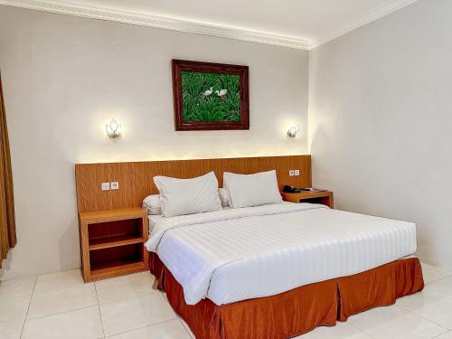 - une chambre avec un grand lit dans l'établissement Votel Manyar Resort Banyuwangi, à Ketapang