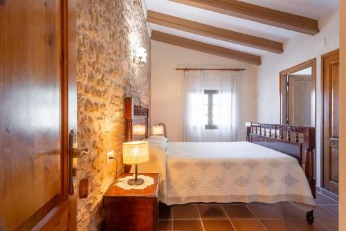 1 dormitorio con 1 cama y 1 lámpara en una mesa en Mas dels Frares, en Vilafreser