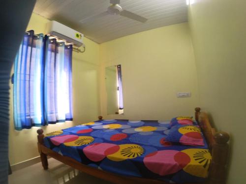 a bedroom with a bed with a colorful comforter at Beach Side homestay in Mangalore