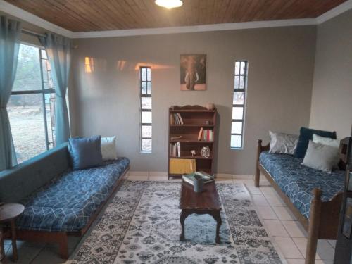 a living room with two couches and a table at Hartbees Boskamp in Dinokeng Game Reserve